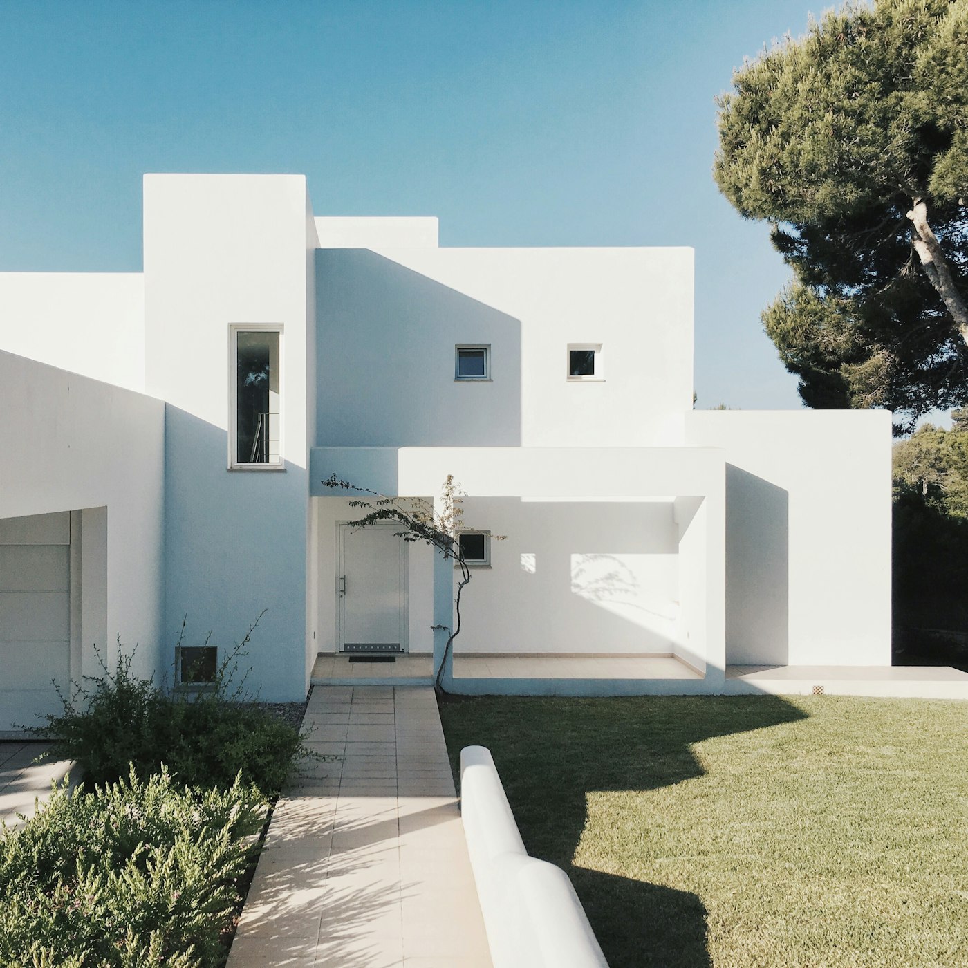 Witte gevel van de villa tussen mediterrane pijnbomen